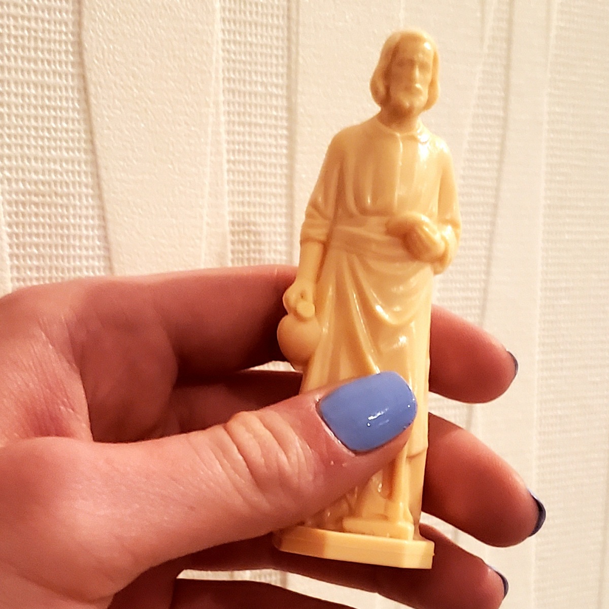 woman's-hand-holding-small-st-joseph-statue-for-home-sellers